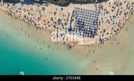 Aerial view of La Pelosa beach at sunny summer day. Stintino, Sardinia island, Italy. Drone view of sandy beach, playing people, clear blue sea. Stock Photo