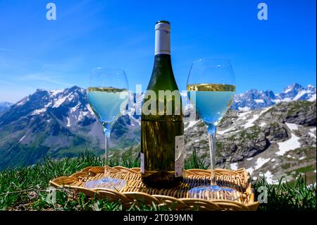 Glass and bottle of dry white Roussette de Savoie or Vin de Savoie wine from Savoy region served on Col du Galibier border Savoy region, France, view Stock Photo