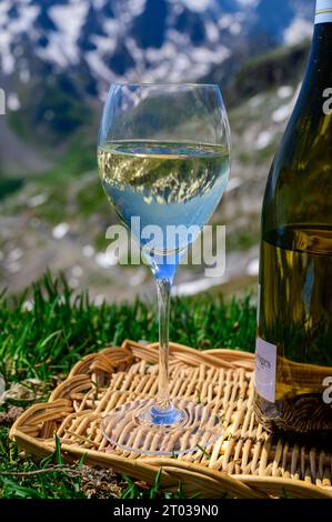 Glass and bottle of dry white Roussette de Savoie or Vin de Savoie wine from Savoy region served on Col du Galibier border Savoy region, France, view Stock Photo