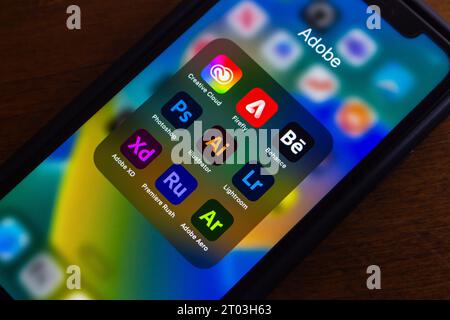 Adobe Creative Cloud Icons (Adobe Firefly, Behance, Photoshop, Adobe Illustrator, Lightroom, XD, Premiere Rush and Aero) seen in iPhone. Stock Photo