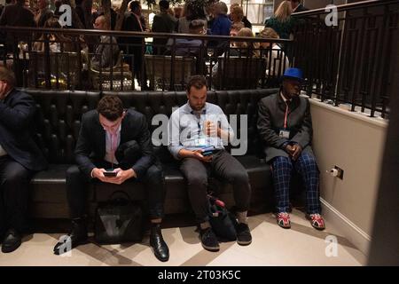 Manchester, UK. 3rd October 2023A delegate in union flag shoes struggles to stay awake as the night rumbles on at the Midland Hotel during the Conservative Party Conference at Manchester Central Convention Complex, Manchester on Tuesday 3rd October 2023. (Photo: Pat Scaasi | MI News) Credit: MI News & Sport /Alamy Live News Stock Photo