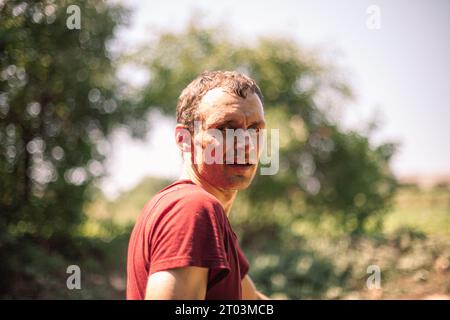 Portrait of tired man standing in the garden during summer heat. Gardener at work Stock Photo
