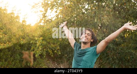 Happy young Arab man enjoying freedom under raindrops enjoying the coolness of summer at sunset. Copy space Stock Photo