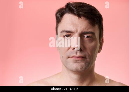 Studio portrait of serious mature man with mole on right cheek Stock Photo