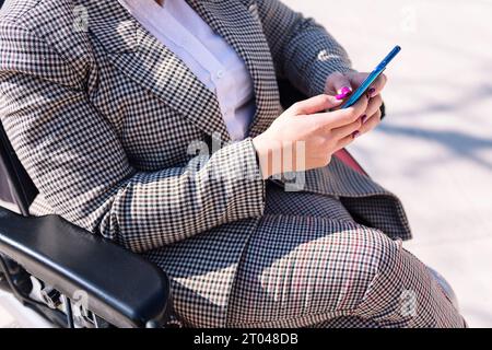 hands of a woman using wheelchair using phone Stock Photo