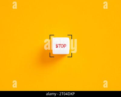 Stop push button. The word stop on white cube on yellow background. Stock Photo