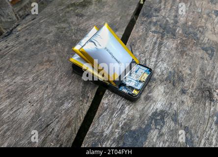 Dangerous swollen batteries ready to explode inside an external power bank, E-waste problem, electronics end of life, environmental impact Stock Photo