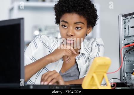 young computer technician typing on laptop Stock Photo