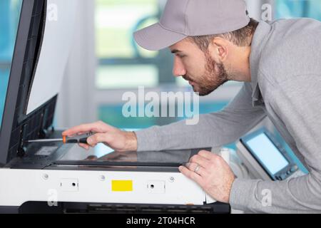young apprentice fixing cartridge in photocopy machine Stock Photo