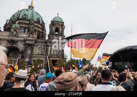 Supporters of the far right party AfD (Alternative for Germany) gather and hold German and AfD party flags in front of the Berlin Cathedral on the 33rd anniversary of German Unity Day. The fall of the Berlin Wall on the 9th of November in 1989, which marked the end of the Cold War, had paved the way for German reunification barely a year later. The Unification Treaty that was signed on the 20th of September in 1990 and declared the 3rd of October the national holiday, sealed the end of the division of Germany. (Photo by Nicholas Muller/SOPA Images/Sipa USA) Stock Photo