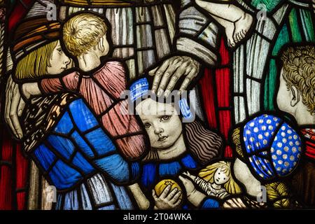 Detail from a stained glass window designed by Robert Anning Bell (1863-1933); children with Jesus. Stock Photo