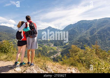 Two happy hiker couple reaching a goal, conquering a hill top enjoying in nature Stock Photo