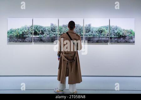London, UK. 04th Oct, 2023. A visitor looks at Monica de Miranda's 'Salt Island' (2022), a series of 5 images depicting verdant landscape. 'RE/SISTERS: A Lens on Gender and Ecology' is a new exhibition at Barbican Art Gallery that brings together the work of nearly 50 artists, surveying the relationship between gender and ecology through film, photography and installation. The exhibition runs until Jan 14th, 2024. Credit: Imageplotter/Alamy Live News Stock Photo