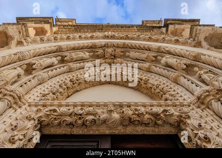 detail of the elaborately carved stonework of the western doorway of sibenik cathedral looking up at the rows of statues of apostles in gothic arch Stock Photo
