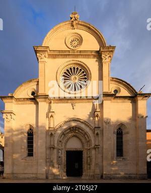 the western facade of sibenik cathedral with two rose windows and elaborately carved doorway in a pointed gothic arch Stock Photo