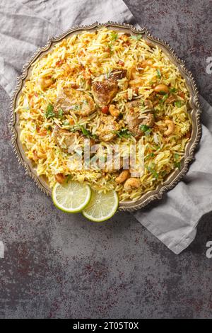 Kacchi Mutton Biryani is a delicious rice dish where tender lamb meat pieces are marinated with lots of spicy closeup on the plate on the table. Verti Stock Photo