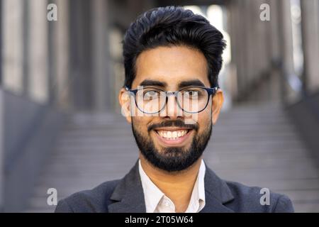 Close up portrait of businessman, man in business suit smiling and looking at camera, successful investor banker outside office building. Stock Photo