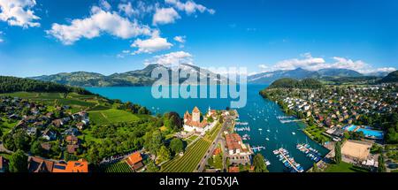 Aerial panoramic view of Spiez Church and Castle on the shore of Lake Thun in the Swiss canton of Bern at sunset, Spiez, Switzerland. Spiez Castle on Stock Photo