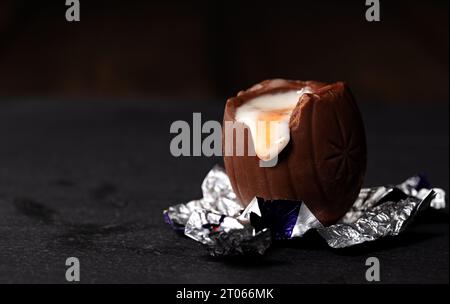 Cadbury's Creme Egg unwrapped sat on its foil Stock Photo