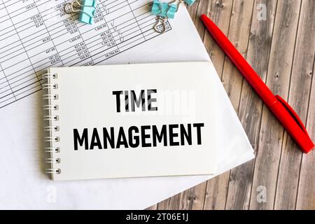 Time Management text on notepad and wooden table with reports and red pen. Business concept. Stock Photo