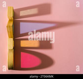 Colorful geometric shapes and their colored shadows on pastel pink background. Minimal optical concept. Abstract geometric background. Flat lay. Stock Photo