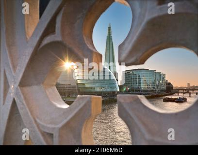 The London Shard, former City Hall and office complex with contemporary London city skyline. The River Thames viewed at sunset through historic old to new with setting sun sunburst, Tower Bridge Gothic style walkway wall London Southwark UK Stock Photo