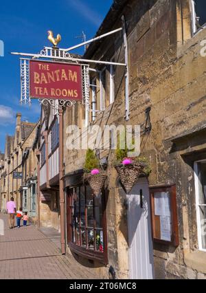 CHIPPING CAMPDEN COTSWOLDS with The Bantam tea rooms in historic Chipping Campden oldie worlde High Street with family strolling along the pavement back view Cotswolds UK Stock Photo