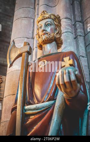 Close-up King holding rich apple, axe and a cross, indoors at St Magnus Cathedral, low angle view, Kirkwall, Scotland, vertical shot Stock Photo