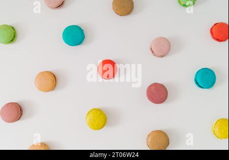 Creative colorful pattern made of various macarons on white background. Minimal sweet food concept. Trendy macaron cookies pattern background. Stock Photo