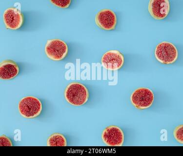 Trendy fruit pattern made of fresh sliced figs on light pastel blue background. Minimal healthy fruit composition. Nature yummy food concept. Flat lay Stock Photo