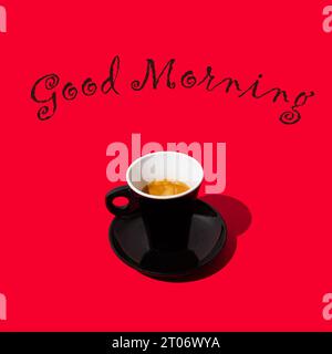 Trendy composition made of black cup of coffee on red background. Fancy 'Good morning' message. Creative coffee concept. Minimal espresso background. Stock Photo