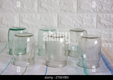 Several clean, empty half-litre glass jars sit upside down on the kitchen table. Time to preserve berries, fruits and vegetables. Stock Photo