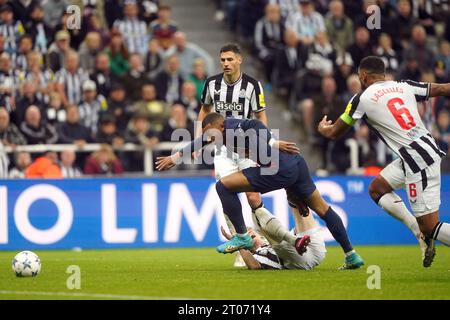 Newcastle United's Anthony Gordon goes down under the challenge from Paris Saint-Germain's Kylian Mbappe during the UEFA Champions League Group F match at St. James' Park, Newcastle upon Tyne. Picture date: Wednesday October 4, 2023. Stock Photo