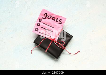 Sticky note with goals for 2024 and gift box on gradient background Stock Photo