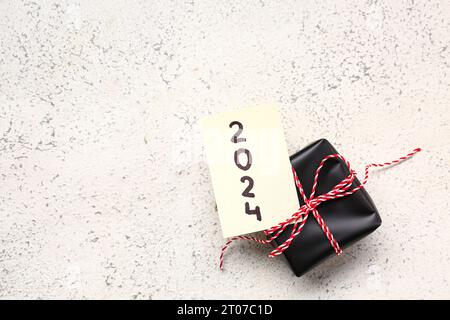 Sticky note with year 2024 and gift box on grunge white background Stock Photo