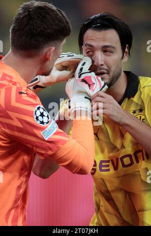 Dortmund, Deutschland, UEFA Champions League, 2. Spieltag Borussia Dortmund : AC Mailand  0-0 04. 10. 2023 im Signal-Iduna Park in Dortmund Erste Hilfe : Der Dortmunder Torwart Gregor KOBEL (BVB) li.- untersucht das Auge seines Mannschaftskameraden  Ramy BENSEBAINI (BVB) re.- auf einen Fremdkörper Foto: Norbert Schmidt, Duesseldorf Stock Photo