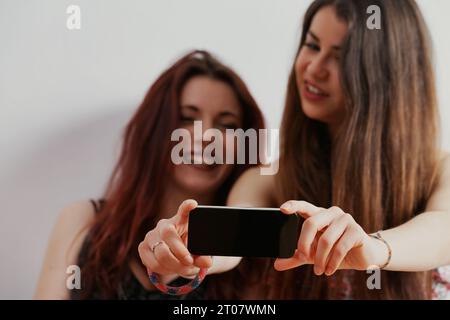 While enjoying their beauty and smartphones, they remain conscious of society's future judgmental gaze Stock Photo