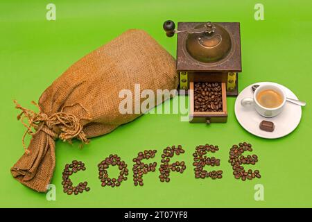 Coffee sack with retro manual grinder espresso cup isolated on green background Stock Photo