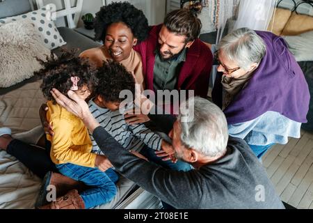 Three generational happy multiethnic diverse family having fun, enjoying time together at home Stock Photo