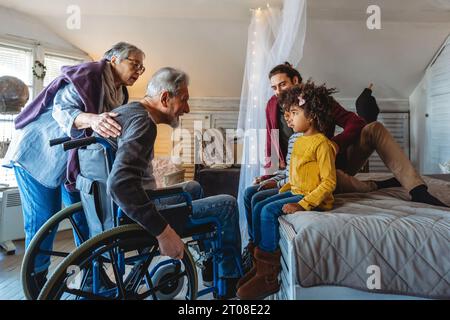 Three generational happy multiethnic diverse family having fun, enjoying time together at home Stock Photo