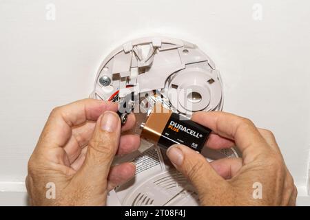 Person replacing the battery in a smoke detector. Concept - home safety, fire safety Stock Photo