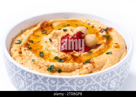 Roasted red pepper hummus in white bowl isolated on white background Stock Photo