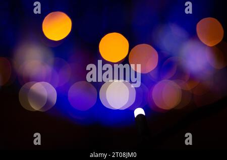 Light Bokeh Background. Blurred image of blue and orange lights at night on a blurry background. Stock Photo