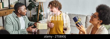 cheerful multiracial relatives smiling and talking actively and exchanging gifts, Christmas, banner Stock Photo