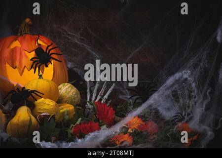 Halloween background with pumpkins, chestnuts, leaves, Halloween decorations, spiders and skeleton hands with cobwebs Stock Photo