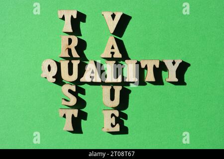 Trust, Quality, Value, words in wooden alphabet letters in crossword form isoalted on green background Stock Photo