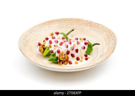 Chiles en Nogada, a traditional Mexican dish made with pablano chili stuffed with meat and fruit and garnished with pomegranate seeds and walnuts Stock Photo