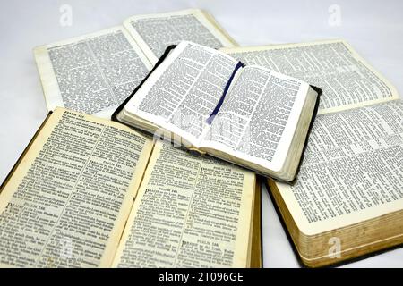 Inside pages of multiple old bibles on a white background Stock Photo