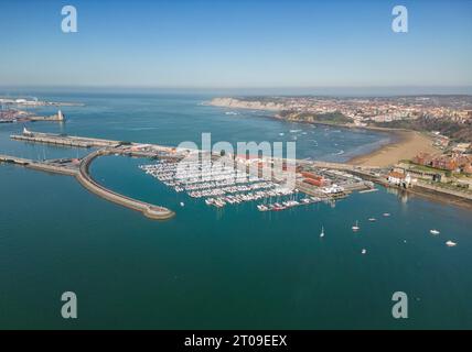 Aerial view of amazing view of Basque coast and surrounding residential buildings near seawater beach against cloudless blue sky in sunny summer day Stock Photo