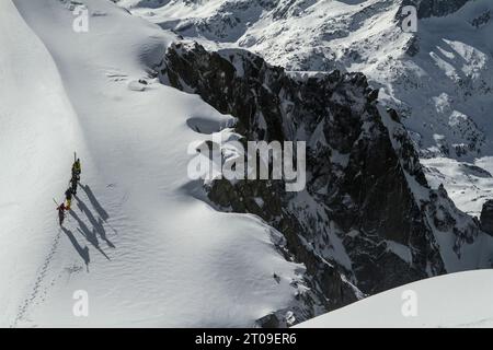 Top view of anonymous people in warm clothes and skis walking on fresh white snow on winter day Stock Photo